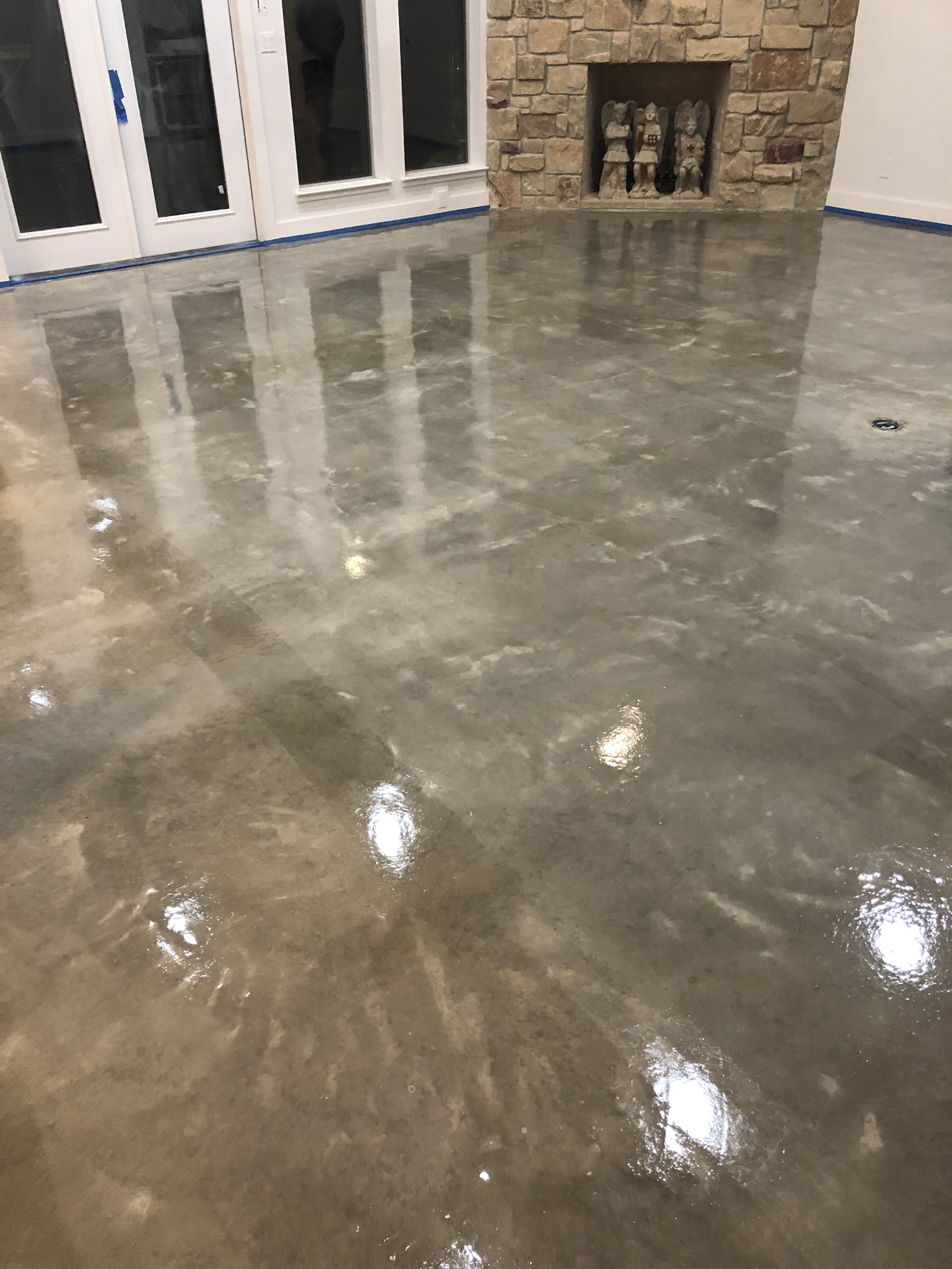 Reflective gray PetraSmooth floor beside a stone fireplace