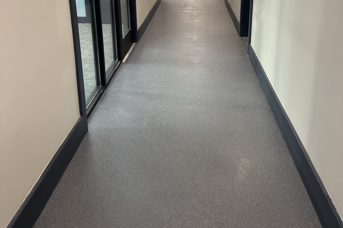 Close view of a completed gray Rezena Quartz floor in a commercial corridor