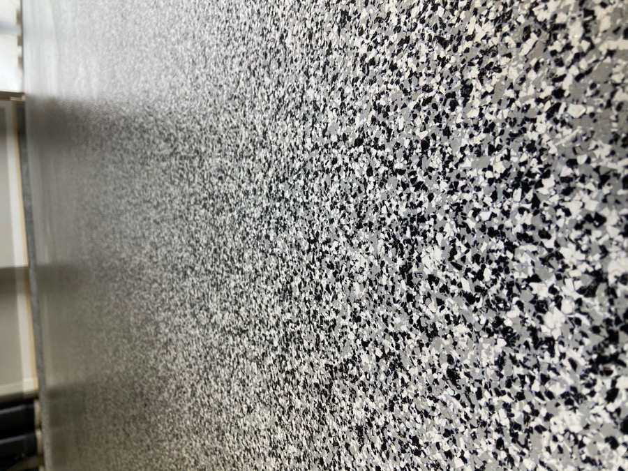 Finished Rezena Flake garage floor with a gray, white, black and blue decorative flake blend