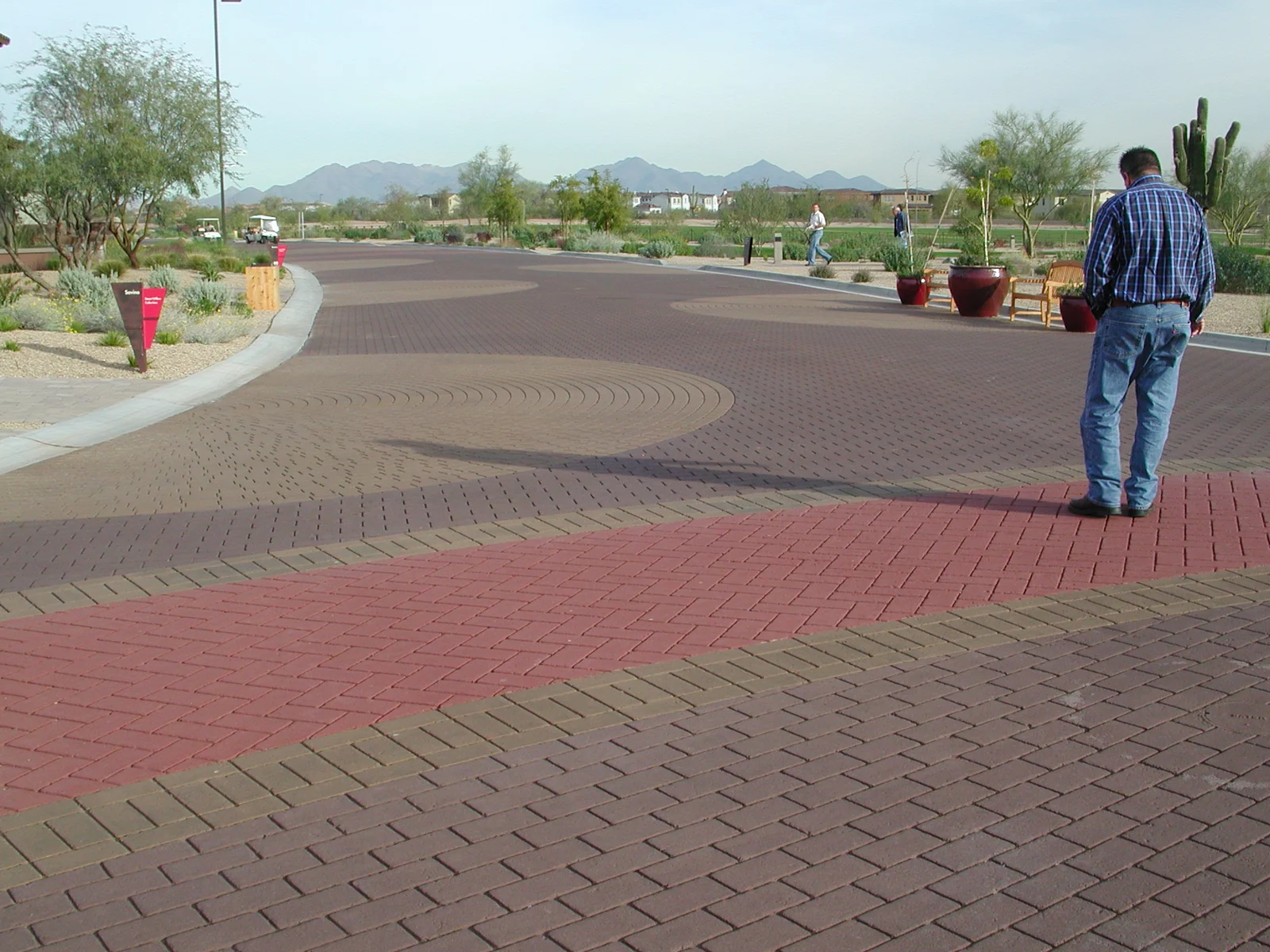 Finished decorative asphalt with brick-like patterning, a curved color band, and a circular accent